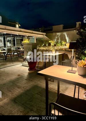 Vue nocturne sur le toit-terrasse du Museu Benaki à Athènes, dotée de sièges extérieurs et d'un éclairage d'ambiance. Banque D'Images