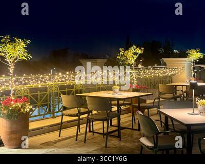 Vue nocturne sur le toit-terrasse du Museu Benaki à Athènes, dotée de sièges extérieurs et d'un éclairage d'ambiance. Banque D'Images