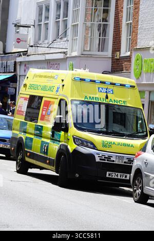 Ambulance d'urgence conduisant dans une rue urbaine très fréquentée pendant la journée. Salisbury, Angleterre Banque D'Images