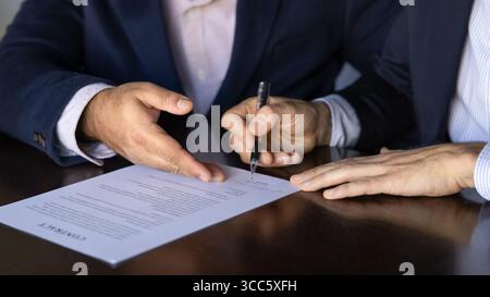 Photo recadrée de deux partenaires commerciaux masculins signant un contrat Banque D'Images