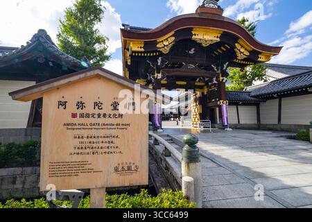 Une vue imprenable sur la porte Higashi Hongan-ji Amidadomon, mettant en valeur l'architecture japonaise traditionnelle sous un ciel bleu vibrant. L'entrée est un des Banque D'Images