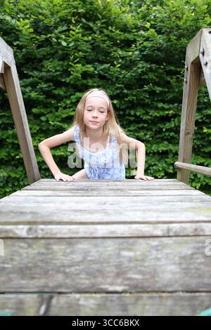 Fille grimpe sur le cadre d'escalade en bois Banque D'Images