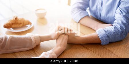 Couple aimant ayant une date romantique, tenant les mains au café urbain, vue rognée Banque D'Images