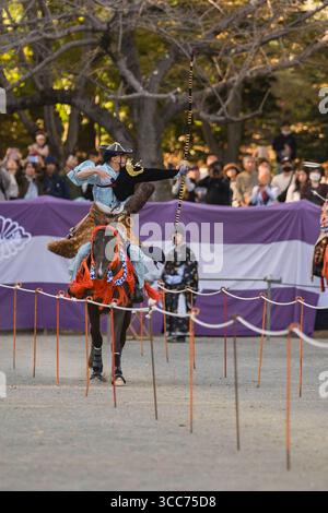 Scène dynamique d'un tir à l'arc traditionnel japonais à cheval pendant le festival Machida Jidai, mettant en vedette un archer visant parfaitement tout en galopant. FR Banque D'Images