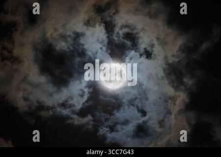 Ciel nocturne sombre avec une pleine lune parmi les nuages sombres Banque D'Images