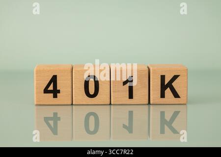 Symbole 401K, un plan de retraite des employés américains. Concept financier. Écrit sur des cubes en bois. Fond bleu clair. copier l'espace Banque D'Images
