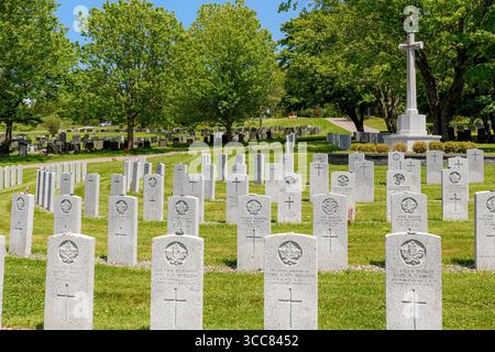 Saint John, N.-B., Canada - 21 juin 2025 : section militaire d'un cimetière canadien. Une grande croix se dresse comme un monument en arrière-plan. Banque D'Images