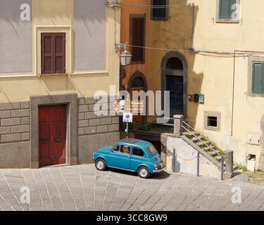 Voiture classique Fiat 500 en bleu garée sur une piazza par une journée ensoleillée avec une forte ombre à Montefiascone, région du Latium, Italie. 11 juin 2025. Banque D'Images