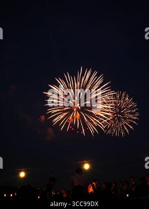 Feux d'artifice dorés illuminant le ciel crépusculaire au-dessus des foules au Itabashi Fireworks Festival 2025 de Tokyo Banque D'Images