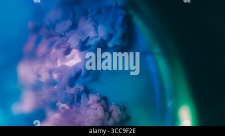 Mélange de nuages. Fond d'encre. Flou violet bleu vert éclaboussure de couleur shimmer liquide texture arc-en-ciel se répandant sur l'abstraction acrylique noir foncé. Banque D'Images