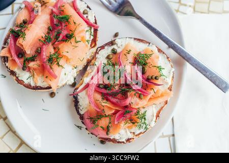 Bagel LOX à l'aneth et à l'oignon mariné — affiche suspendue sur assiette blanche Banque D'Images