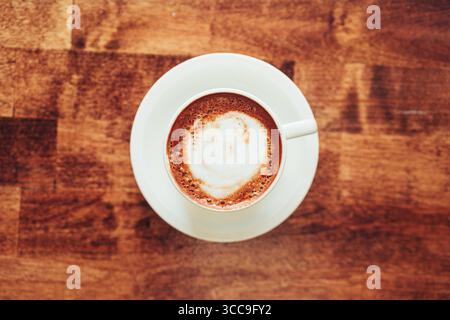 Vue aérienne de Cappuccino avec Swirl de mousse sur la table en bois Banque D'Images