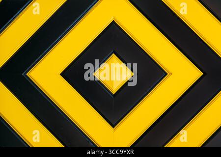 Motif géométrique avec alternance de formes de losanges noir et jaune dans une disposition symétrique. Abstraction visuelle, théorie des couleurs, design moderne Banque D'Images