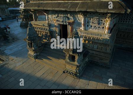 Vue aérienne de sculptures complexes ornent la façade de l'ancien temple, projetant des ombres sur les marches de pierre, un témoignage de l'art, Belur, Karnataka, Inde. Banque D'Images
