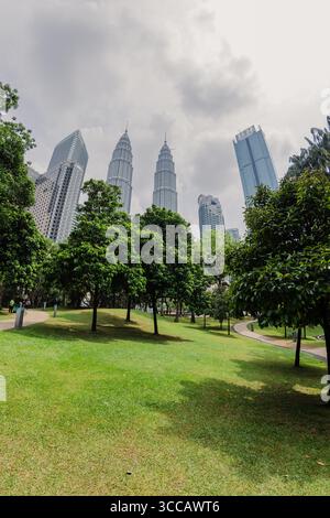 15 juillet 2025. Kuala Lumpur, Malaisie. Parc et gratte-ciel en journée ensoleillée. Tours jumelles dans le centre-ville. Banque D'Images