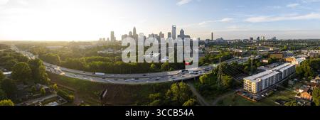 Charlotte, États-Unis - 30 juillet 2025 : vue aérienne de l'horizon lumineux de Charlotte, où les gratte-ciel imposants rencontrent la verdure luxuriante canopée et une autoroute animée. Banque D'Images