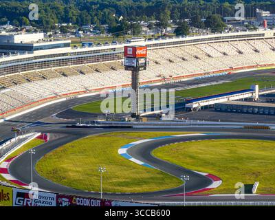 Concord, États-Unis - 28 juillet 2025 : vue aérienne de la piste sinueuse du Charlotte Motor Speedway, des tribunes se prélassant au soleil et de la tour Coca-Cola perçant le ciel. Banque D'Images