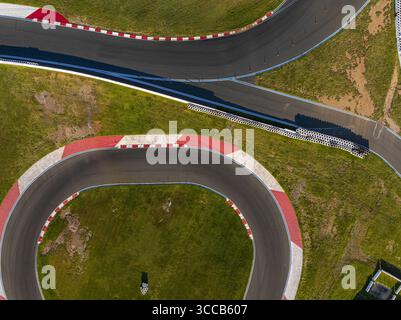 Concord, États-Unis - 28 juillet 2025 : vue aérienne de l'asphalte sinueux du Charlotte Motor Speedway, un ruban de gris traversant les champs verts vibrants. Banque D'Images