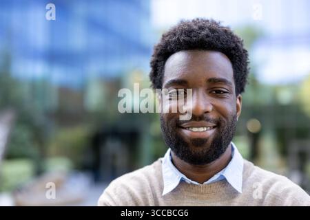Portrait d'un individu en plein air, exsudant confiance et chaleur avec un comportement joyeux. Cette image met en évidence le charme personnel et la positivité agai Banque D'Images