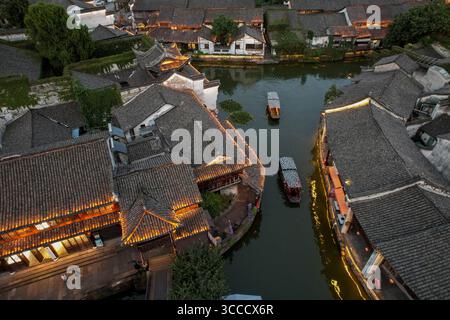 Pékin, Chine. 9 août 2025. Une photo de drone aérien prise le 9 août 2025 montre une vue nocturne de la ville antique de Xinshi dans le comté de Deqing, dans la province chinoise du Zhejiang. Les zones pittoresques à travers la Chine sont entrées en haute saison pour le tourisme pendant les vacances d'été. Crédit : Yao Haixiang/Xinhua/Alamy Live News Banque D'Images