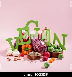 Le mot VEGAN en grandes lettres vertes sur la table rose, entouré de fruits frais, légumes et un bol de lentilles, régime végétalien nature morte Banque D'Images