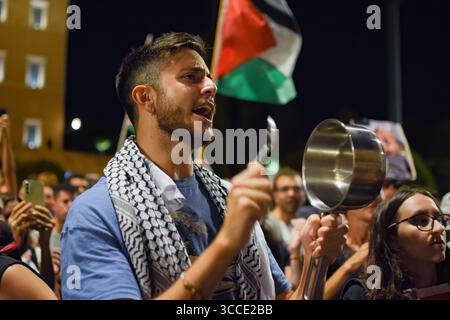 Athènes, Grèce, 10 août 2025. Un manifestant frappe un pot vide devant le Parlement lors d'une manifestation condamnant la famine à Gaza et l'arrivée de soldats israéliens en vacances en Grèce. Le rallye était l'un des 100 événements similaires organisés à travers la Grèce le même jour. Crédit : Dimitris Aspiotis/Alamy Live News Banque D'Images
