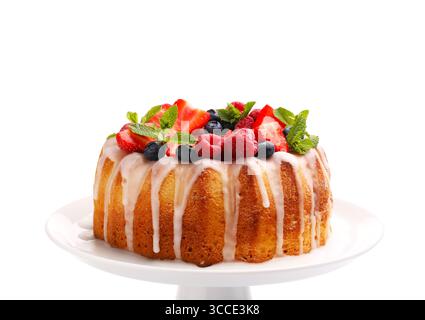 Délicieux gâteau bundt aux baies, glaçage et menthe isolé sur blanc Banque D'Images