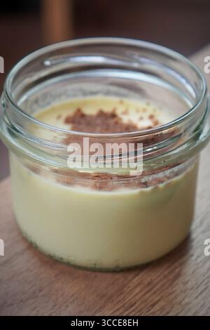 Portion de dessert en pot présentée avec une garniture de chapelure, appropriée pour servir comme plat de dessert. Banque D'Images