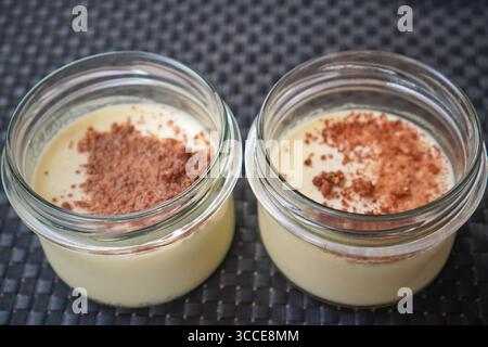 Vue de haut en bas de deux pots à dessert mettant en valeur la chapelure et les couches crémeuses. Banque D'Images
