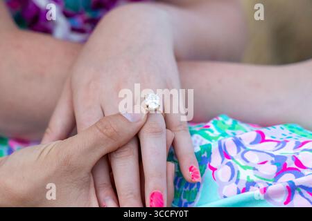 Gros plan de la main d'une femme présentant une bague de fiançailles en diamant, capturant un moment calme d'amour, d'élégance et de promesse d'un engagement intemporel pour toujours Banque D'Images