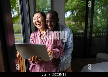 Un couple heureux et multinational qui sont des nomades numériques et travaillent dans un pays différent chaque mois Banque D'Images