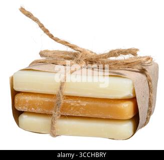 Trois morceaux de savon naturel sont enveloppés dans du papier artisanal et attachés avec de la ficelle épaisse, attachés dans un arc. Arrière-plan isolé Banque D'Images