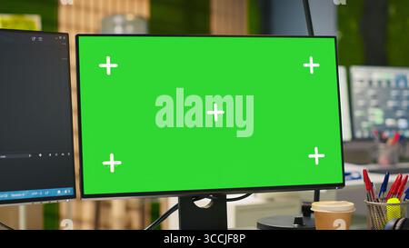 Bureau de démarrage vide avec PC à écran vert et programme d'intelligence artificielle fonctionnant sur des moniteurs. Affichage d'ordinateur maquette dans l'espace de travail de démarrage de l'industrie de l'IA exploitant la technologie d'apprentissage automatique Banque D'Images