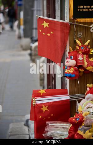 Drapeaux chinois et jouets dragon exposés devant un magasin à Pékin, en Chine, le 19 avril 2024 Banque D'Images