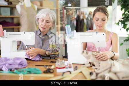 Deux couturières assises et travaillant dans l'atelier Banque D'Images