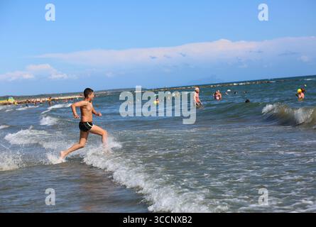 Rome. 26 juillet 2025. Les gens se rafraîchissent dans la mer près de Nettuno en Italie, 26 juillet 2025. Les Italiens profitent de diverses activités pendant la saison des vacances d'été. Crédit : Li Jing/Xinhua/Alamy Live News Banque D'Images