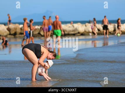 Rome. 26 juillet 2025. Un bébé se promène sur la plage près de Nettuno en Italie, le 26 juillet 2025. Les Italiens profitent de diverses activités pendant la saison des vacances d'été. Crédit : Li Jing/Xinhua/Alamy Live News Banque D'Images