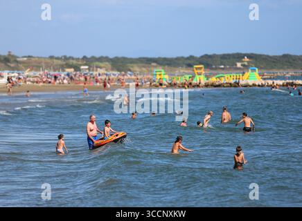 Rome. 26 juillet 2025. Les gens se rafraîchissent dans la mer près de Nettuno en Italie, 26 juillet 2025. Les Italiens profitent de diverses activités pendant la saison des vacances d'été. Crédit : Li Jing/Xinhua/Alamy Live News Banque D'Images
