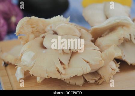 Champignons d'huître frais sur une planche à découper en bois Banque D'Images
