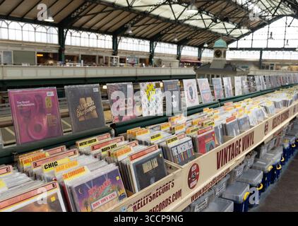 CARDIFF, Royaume-Uni - 8 AOÛT 2025 - parcourant des disques vinyles d'époque dans un étal du marché de Cardiff, au pays de Galles, à la recherche de trésors musicaux Banque D'Images
