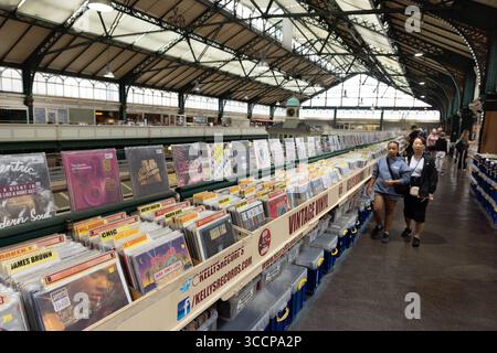 CARDIFF, Royaume-Uni - 8 AOÛT 2025 - deux clients regardent des disques vinyles chez Kellys Records, un stand au Cardiff Market, un marché couvert dans la ville de Cardiff cen Banque D'Images