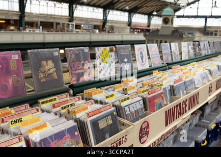 CARDIFF, Royaume-Uni - 8 AOÛT 2025 - parcourant des disques vinyles vintage sur un stand de marché à Cardiff Market, pays de Galles Banque D'Images