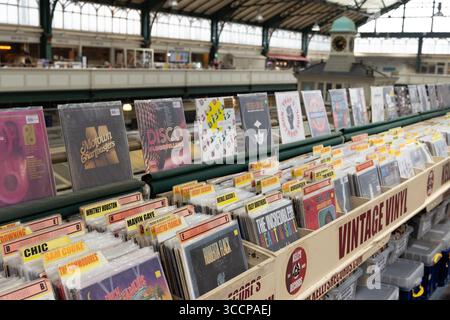 CARDIFF, Royaume-Uni - 8 AOÛT 2025 - parcourant des disques vinyles vintage dans un stand du marché de Cardiff, au pays de Galles, mettant en vedette divers artistes et genres Banque D'Images