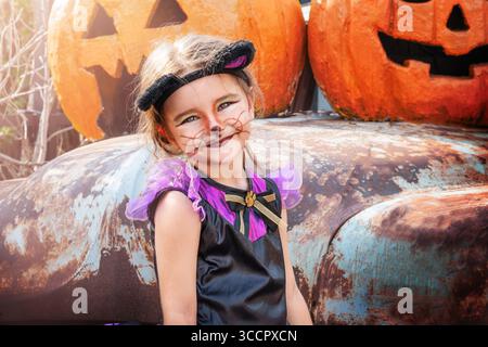 Portrait de fille d'enfant en costume de chat près des décorations d'halloween Banque D'Images