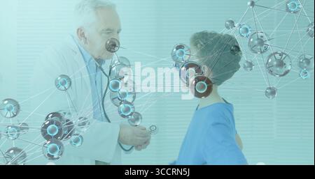 Le docteur en blouse blanche qui place le stéthoscope sur la poitrine du garçon dans la salle d'examen, avec superposition réseau Banque D'Images