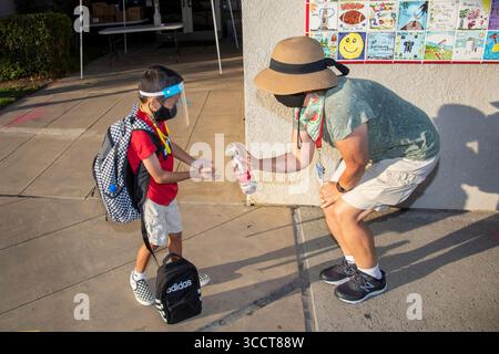 2 octobre 2020 : arrivé pour le premier jour d’école pendant la pandémie de corornavirus, un élève de première année est accueilli par un enseignant avec une giclée de désinfectant pour les mains. (Crédit image : © Spencer Grant/ZUMA Press Wire) Banque D'Images