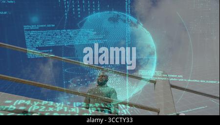 Regardant l'homme dans le pull vert regardant le globe numérique sur le balcon avec des flux de code, balustrade en métal Banque D'Images
