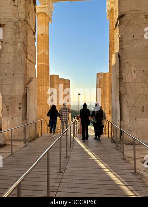 Coucher de soleil heure d'or à l'entrée du complexe de l'Acropole (Acrópole Propileia) à Athènes, Grèce, avec des touristes marchant dans les escaliers. Banque D'Images