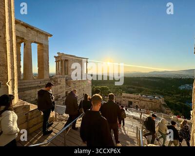Coucher de soleil heure d'or à l'entrée du complexe de l'Acropole (Acrópole Propileia) à Athènes, Grèce, avec des touristes marchant dans les escaliers. Banque D'Images