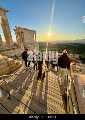 Coucher de soleil heure d'or à l'entrée du complexe de l'Acropole (Acrópole Propileia) à Athènes, Grèce, avec des touristes marchant dans les escaliers. Banque D'Images